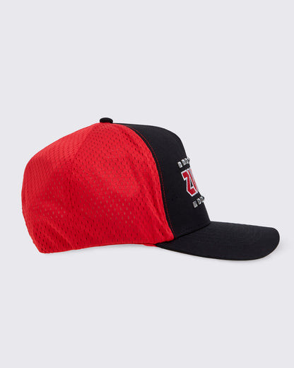 Side view of a two-tone trucker-style baseball cap showing more of the red panel mesh