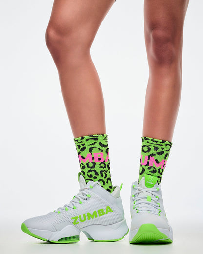 Female model wearing green leopard print socks with matching green and white shoes.