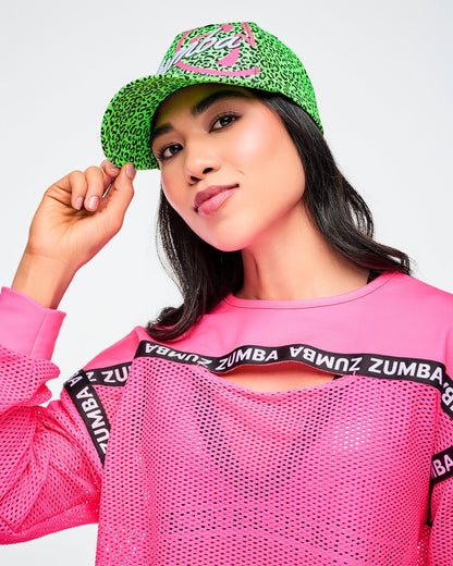 Female model wearing green and black leopard print hat and paired with a pink Zumba top.