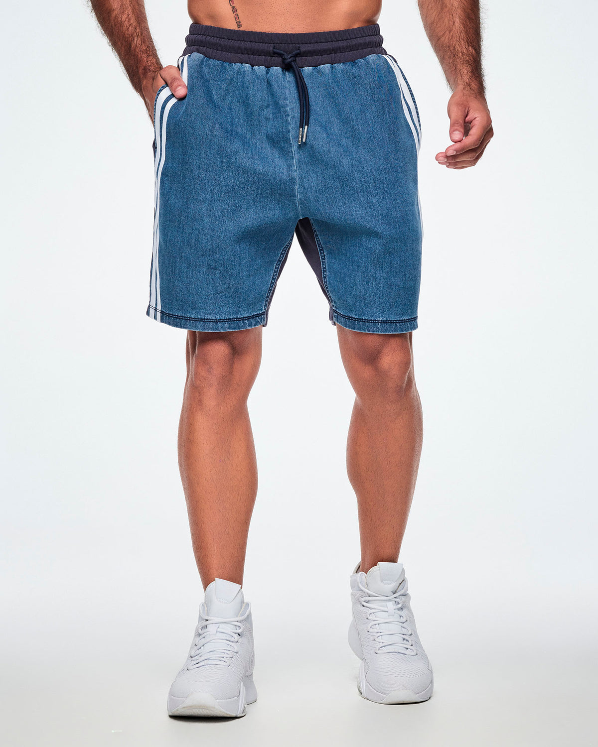 Front view of a male model wearing denim combo shorts with a navy waistband, drawcord, and double white stripe along the pocket edge.