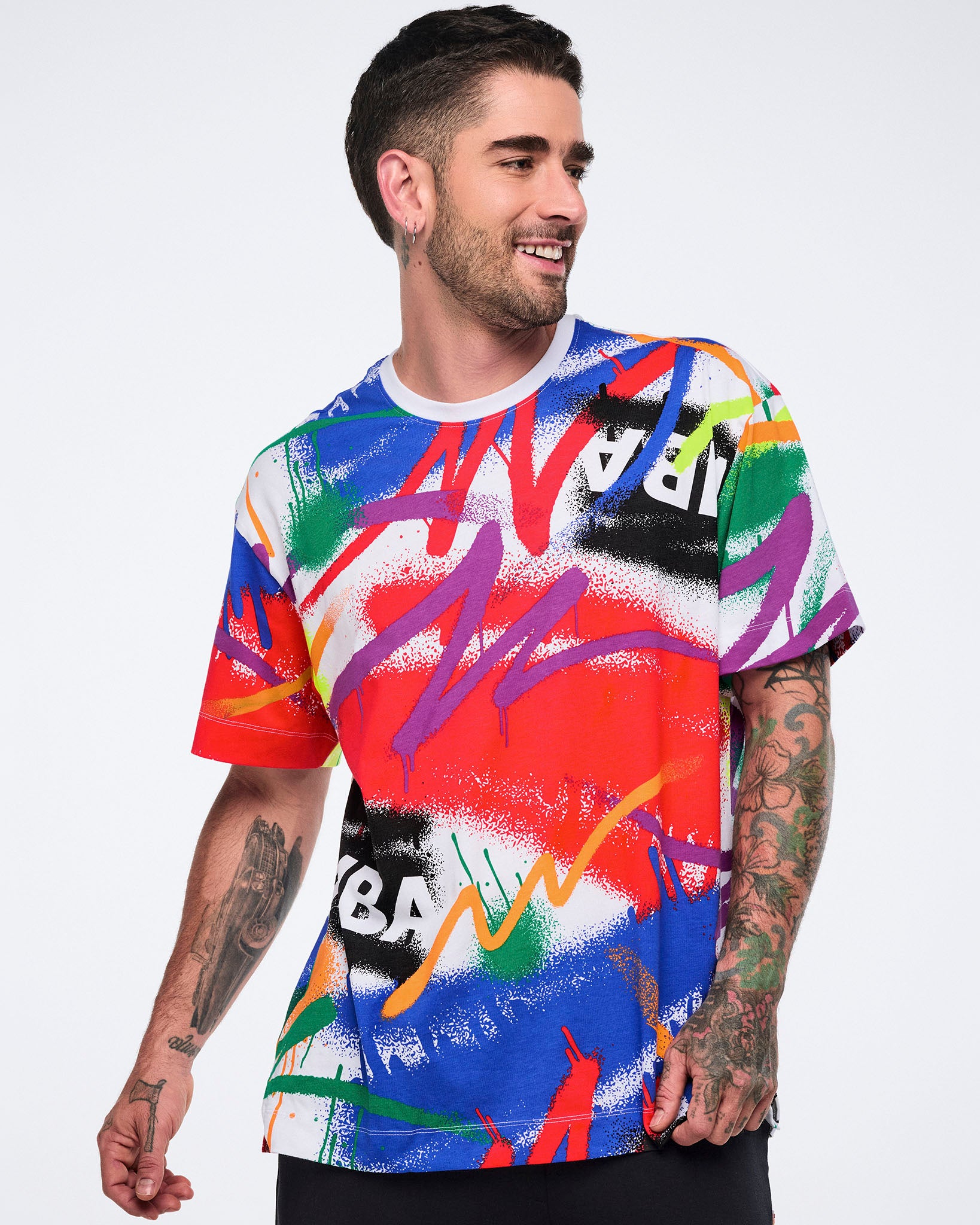 Male model wearing a colorful graphic t-shirt with a white background.