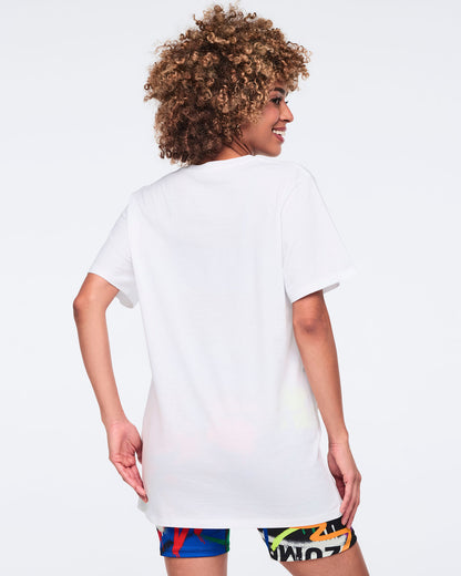 Back view of a female model wearing a white t-shirt with colorful biker shorts on a white background.