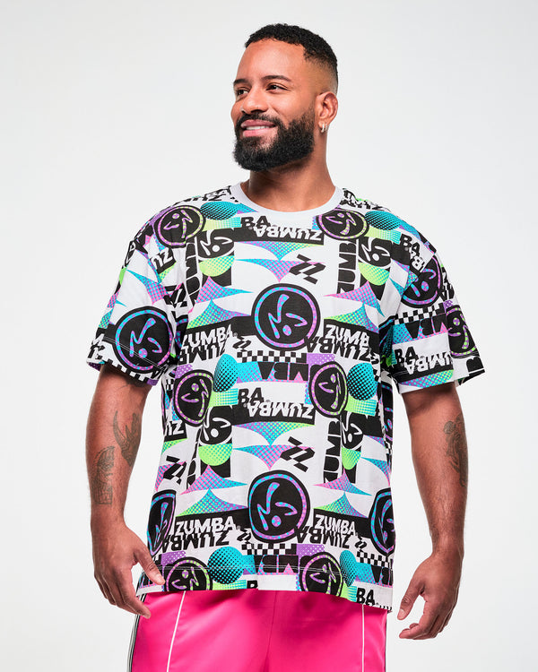 Male model wearing a white tee with a busy black, purple, and aqua graphic pattern of repeated 