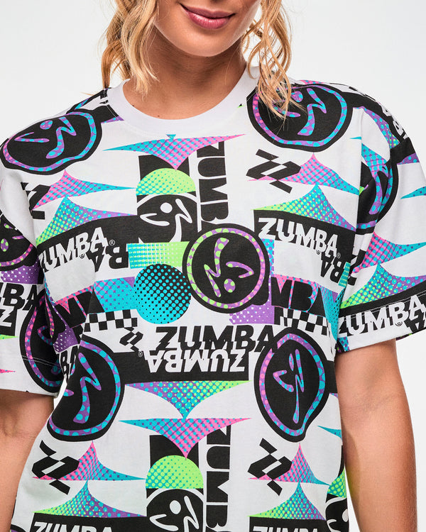Close-up of a white tee with a busy black, purple, and aqua graphic pattern featuring repeated 