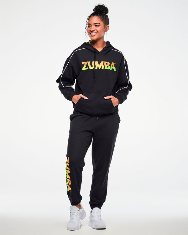 Female model wearing a black hoodie and matching joggers with a gradient 
