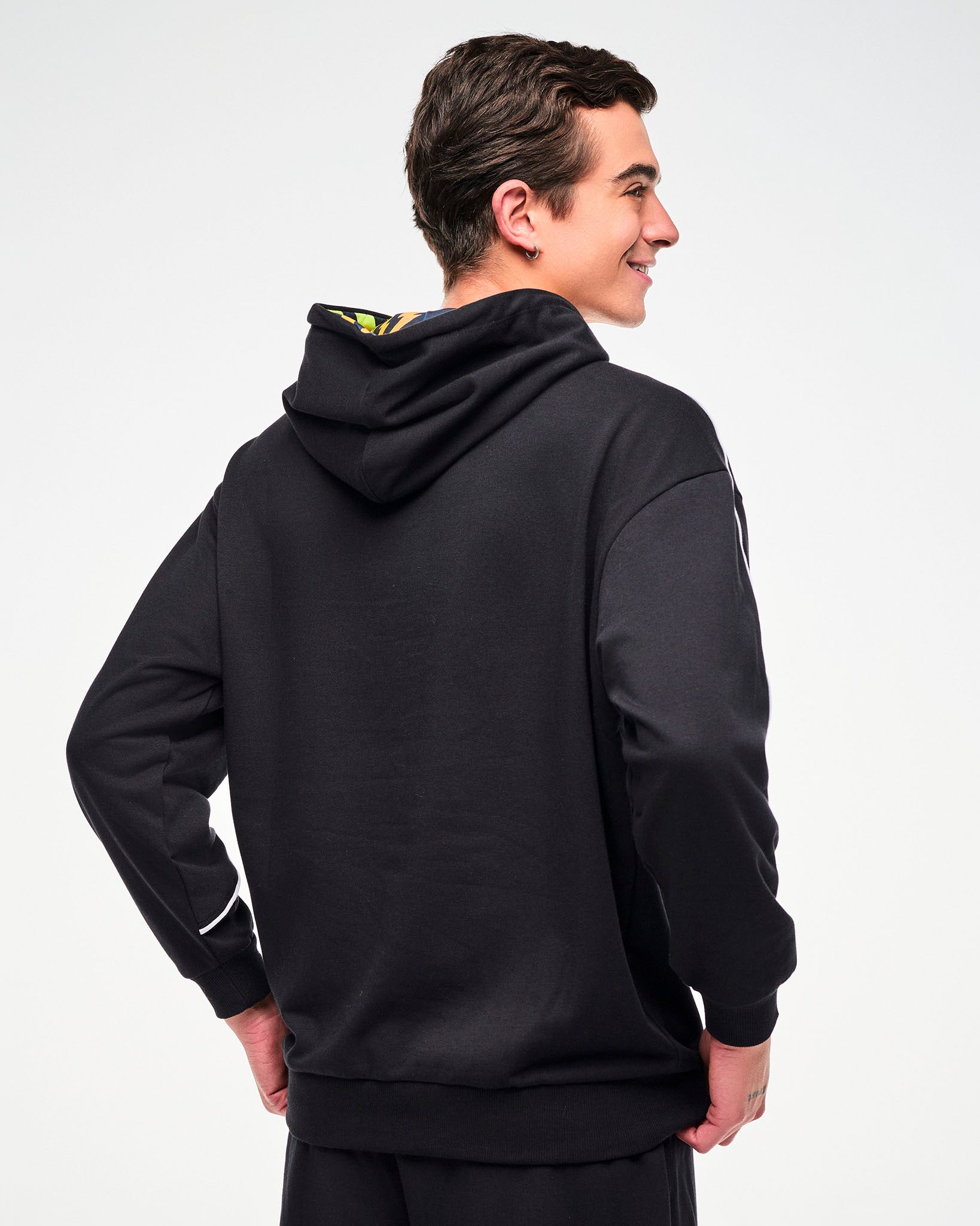 Shown from the back, male model wearing a black hoodie.