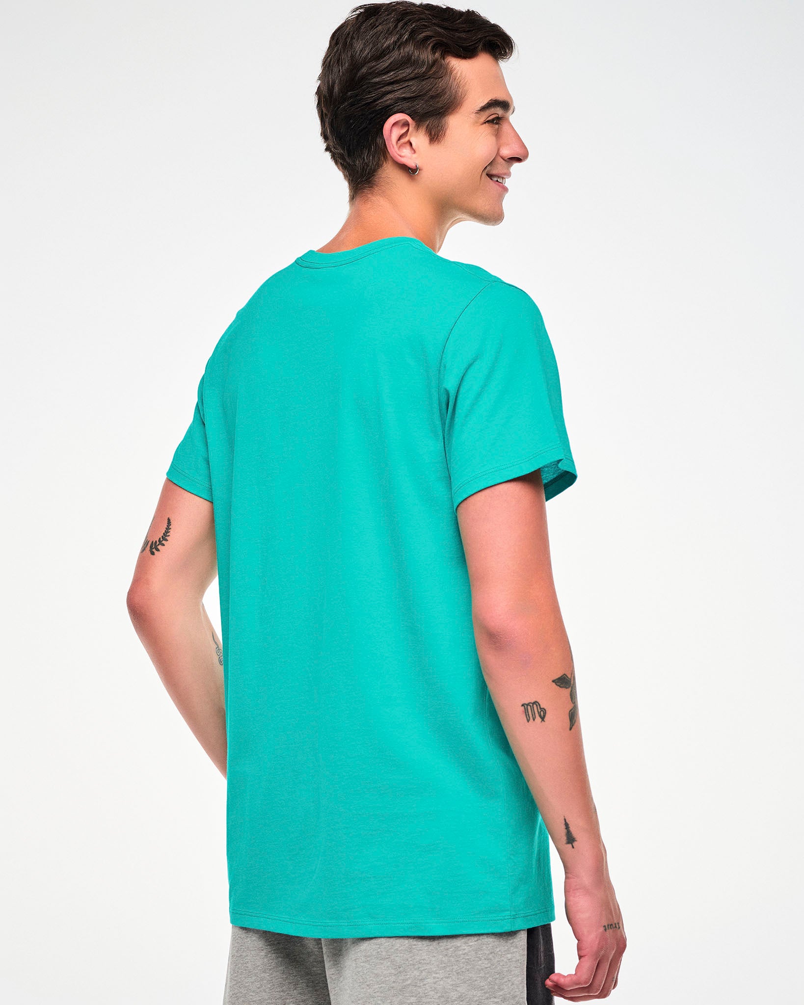 Shown from the back, male model wearing an aqua tee.