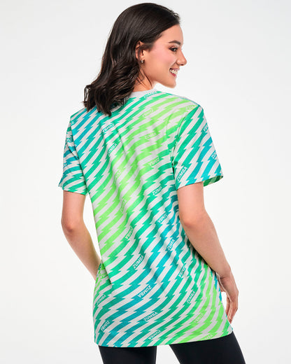 Female model wearing a green and aqua lightning bolt-striped tee with "ZUMBA" text, shown from the back.
