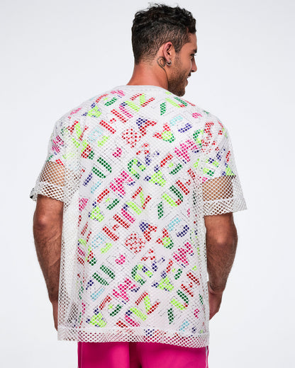 Back view of a male model wearing a colorful patterned shirt with a white mesh top layered over it, paired with pink pants.