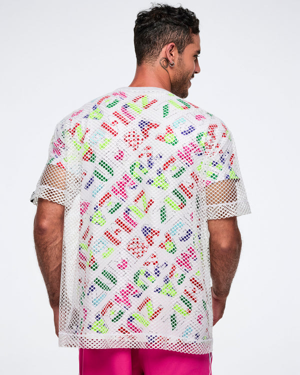 Back view of a male model wearing a colorful patterned shirt with a white mesh top layered over it, paired with pink pants.