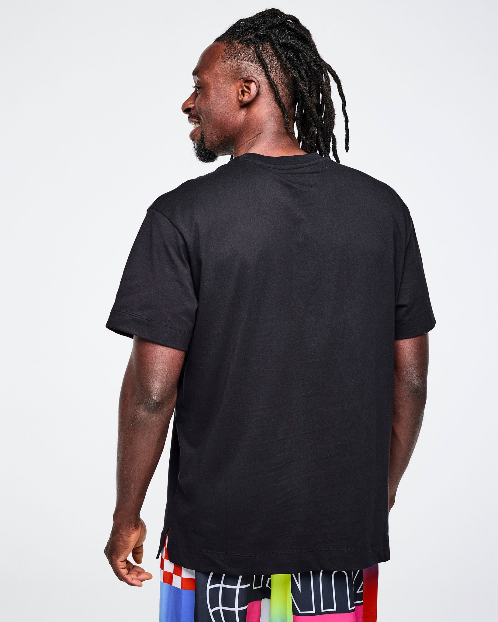 Back view of a male model wearing a black t-shirt on a white background.