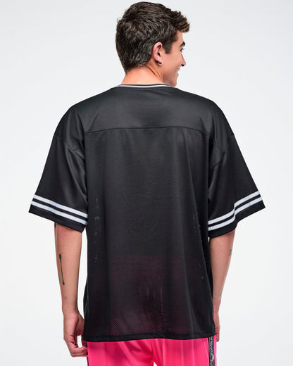 Back view of a a male model wearing a black Zumba jersey paired with pink pants.