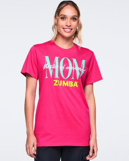 Bright pink short-sleeve Zumba T-shirt with oversized aqua “MOM,” white “Master of movement,” and neon yellow “ZUMBA” text on the front. Female model wears the crewneck tee with black pants, shown from the front against a light gray background.