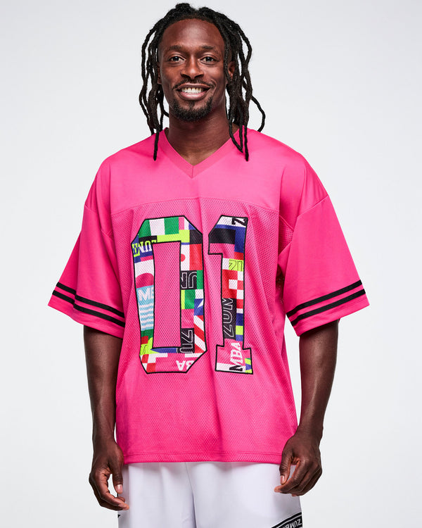 Male model wearing a pink mesh sports top with colorful number design on a white background.