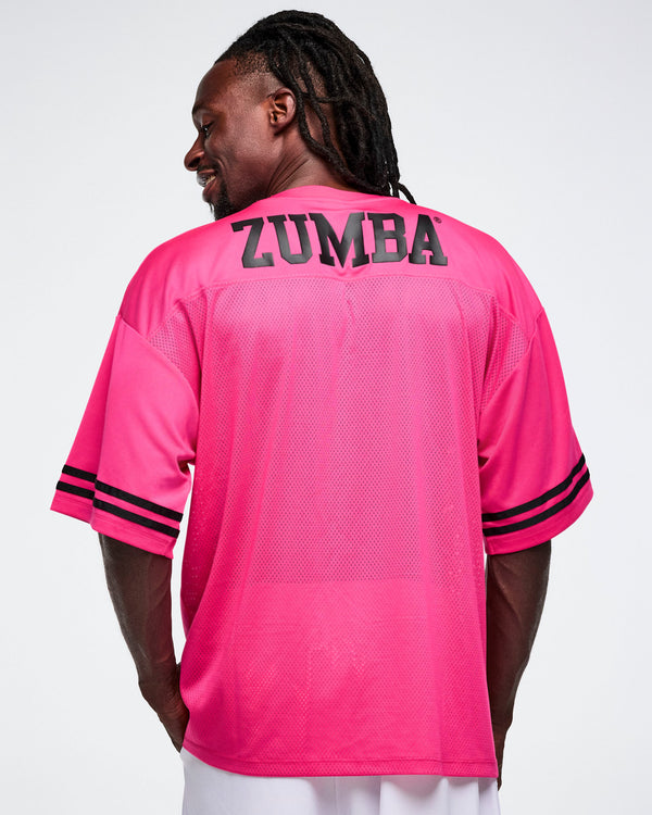 Male model, shown from the back, wearing a pink mesh Zumba jersey with 'Zumba' printed on the back.